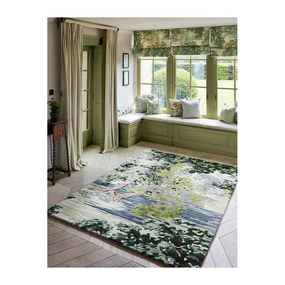 Sanderson Ancient Canopy Forest Green Designer Rug featuring forest landscape in greens and blues on pale green background, hand-tufted wool