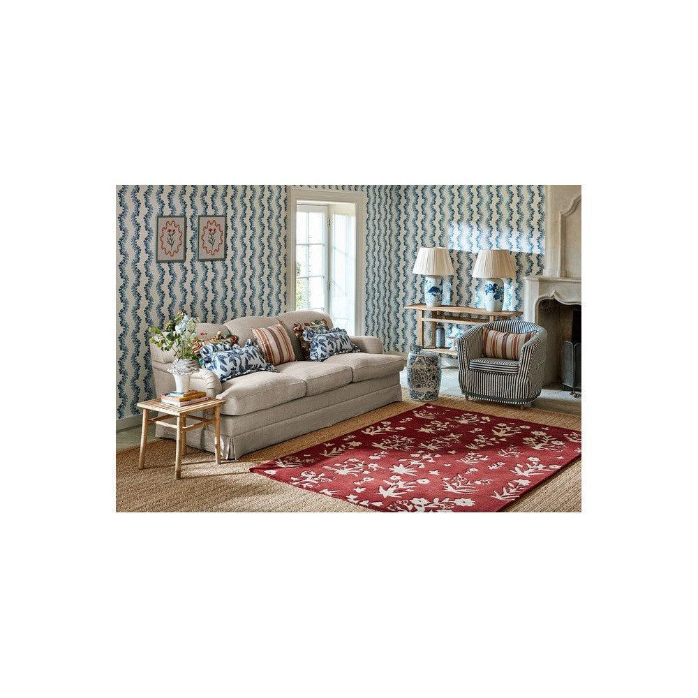 Sanderson Woodland Glade Damson Red Designer Rug featuring florals in damson red and ivory on warm beige floor, hand-tufted wool