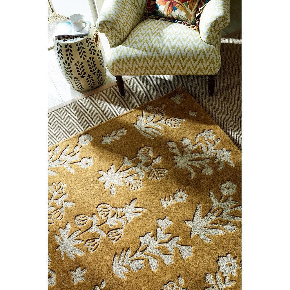 Sanderson Woodland Glade Gold Designer Rug featuring ivory floral pattern on warm mustard background, hand-tufted wool