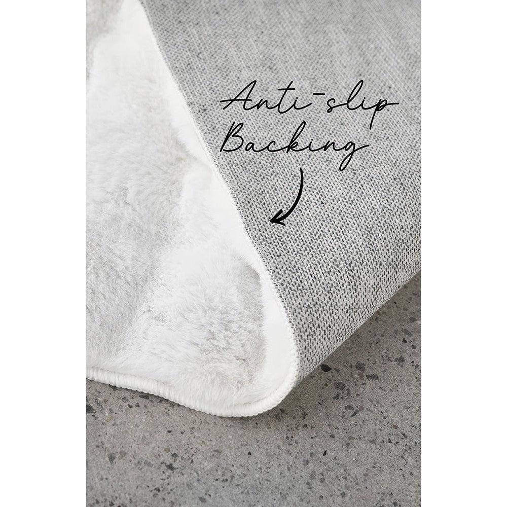 Bubble White rug featuring plush solid texture with anti-slip backing in white and light grey on concrete grey background, machine-washable microfiber