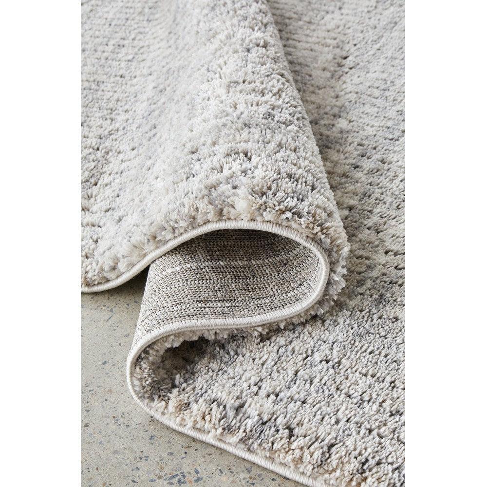 Himali Charlie Pewter Rug featuring solid shag texture in pewter grey with ivory/cream on light concrete background, machine-woven polyester