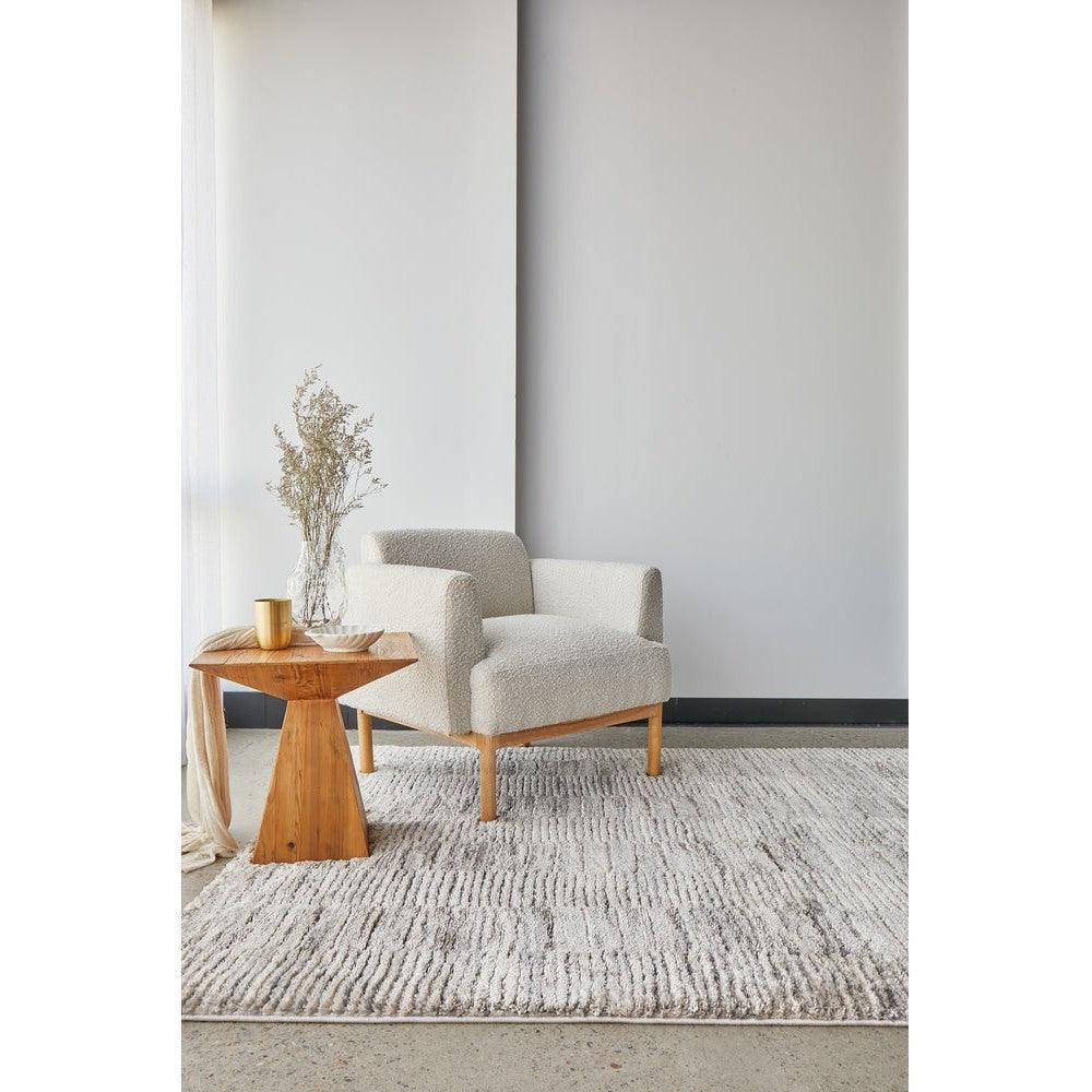Himali Fin Steel Rug featuring textured striped pattern in steel grey, ivory and taupe on light grey floor, woven wool blend