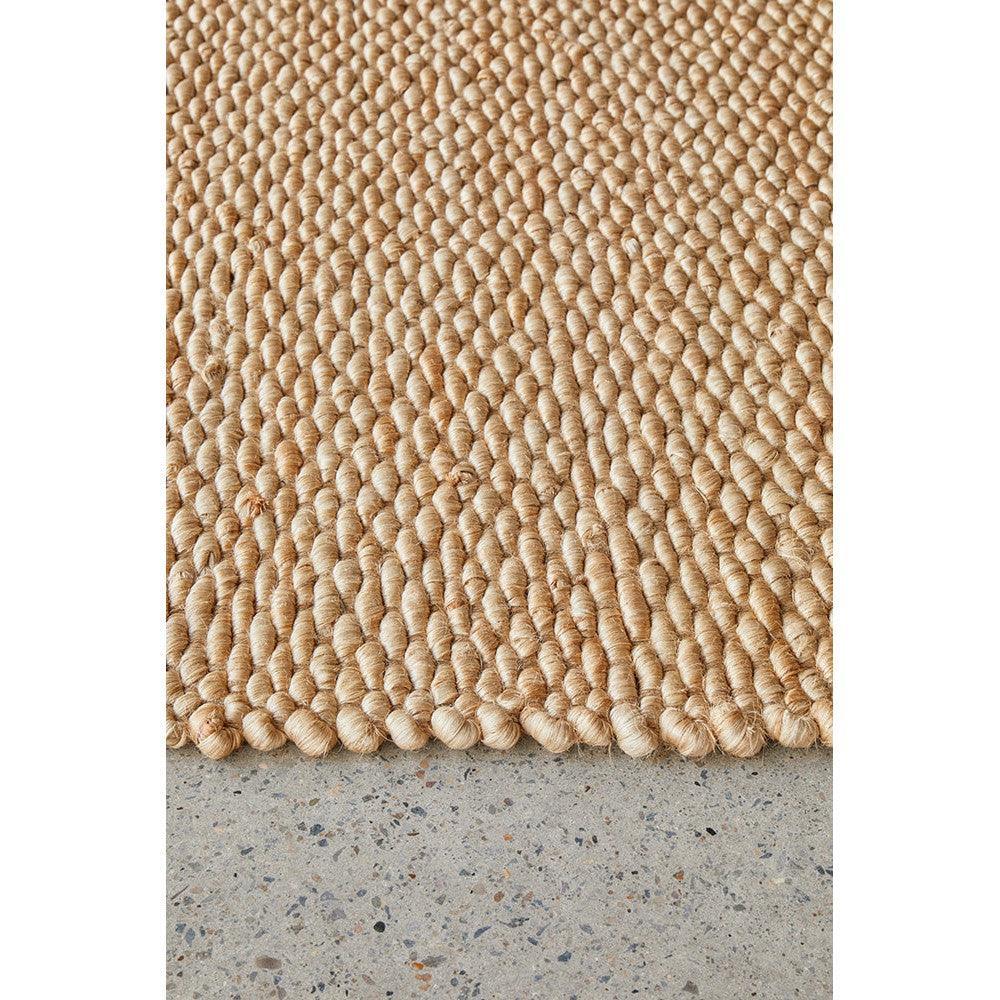 Hive Natural Rug featuring chunky loop texture in warm beige, taupe and sand on concrete grey, hand-woven jute