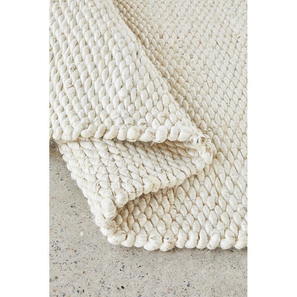 Hive White Rug featuring chunky looped texture in ivory/cream on concrete backdrop, hand-woven cotton