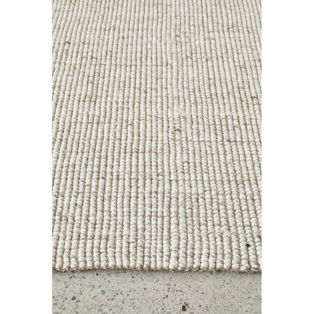 Harlow Ariel Beige Rug featuring chunky looped weave in beige and cream on light concrete floor, hand-woven jute