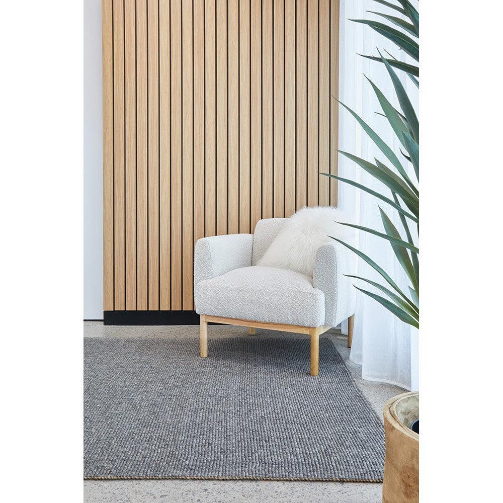 Harlow Ariel Graphite Rug featuring textured weave in graphite grey on light neutral floor, hand-tufted wool
