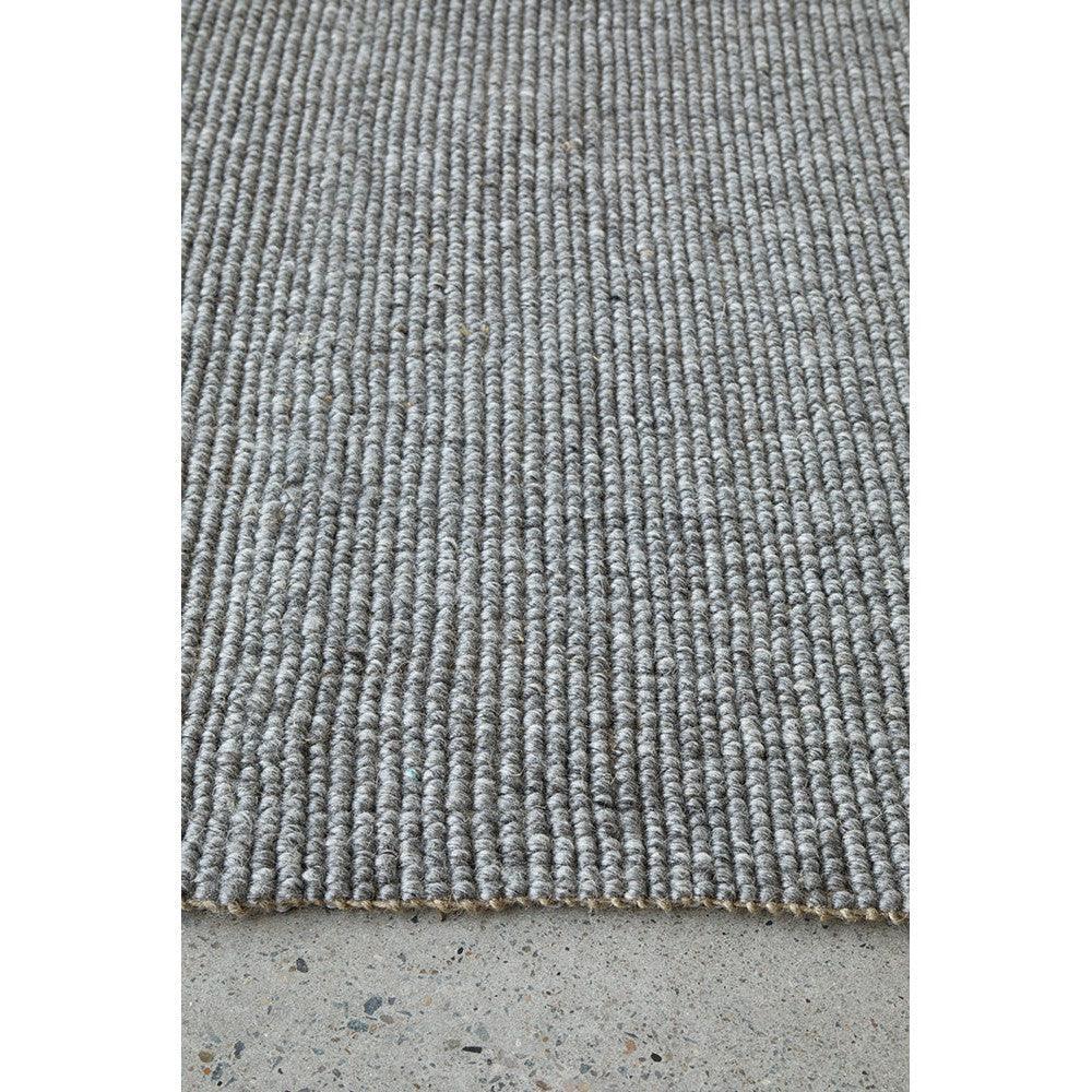Harlow Ariel Graphite Rug featuring ribbed texture in graphite grey and light grey on concrete-grey background, machine-made fibre