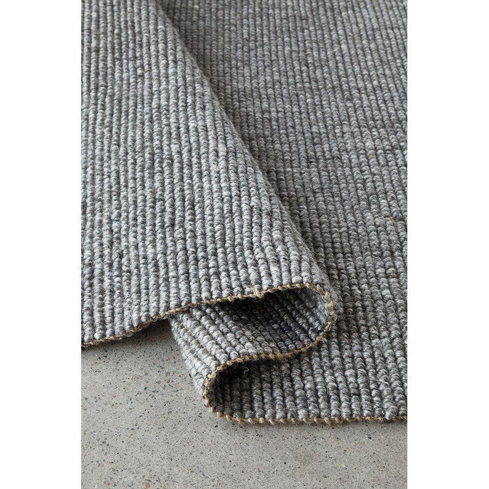 Harlow Ariel Graphite Rug featuring ribbed woven texture in graphite grey on light grey background, hand-woven wool