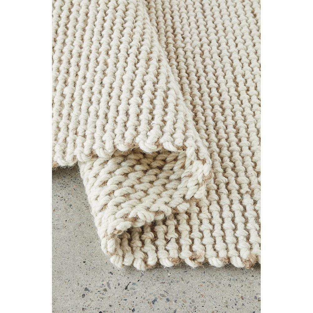 Harlow Cove Cream Rug featuring chunky knit design in cream on gray concrete floor, hand-tufted wool