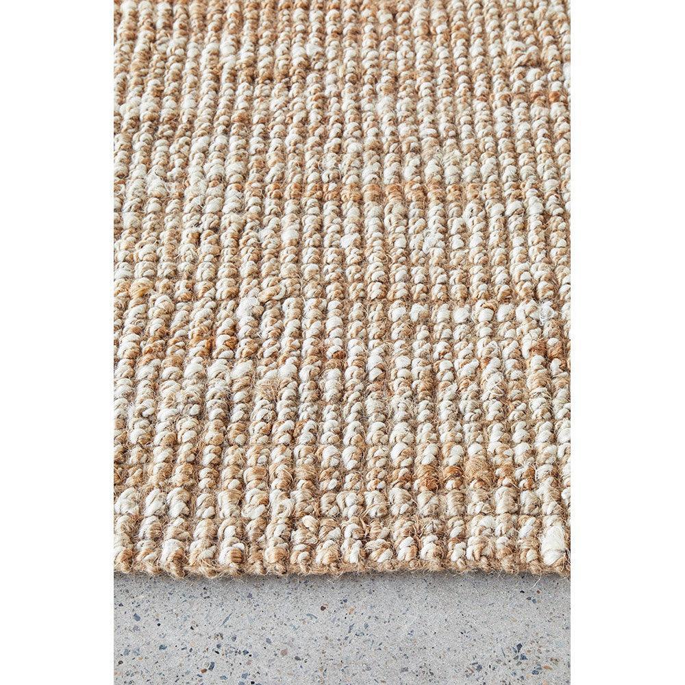 Harlow Hunter Natural Rug featuring textured loop weave in beige, tan and ivory on concrete grey background, handwoven jute rug
