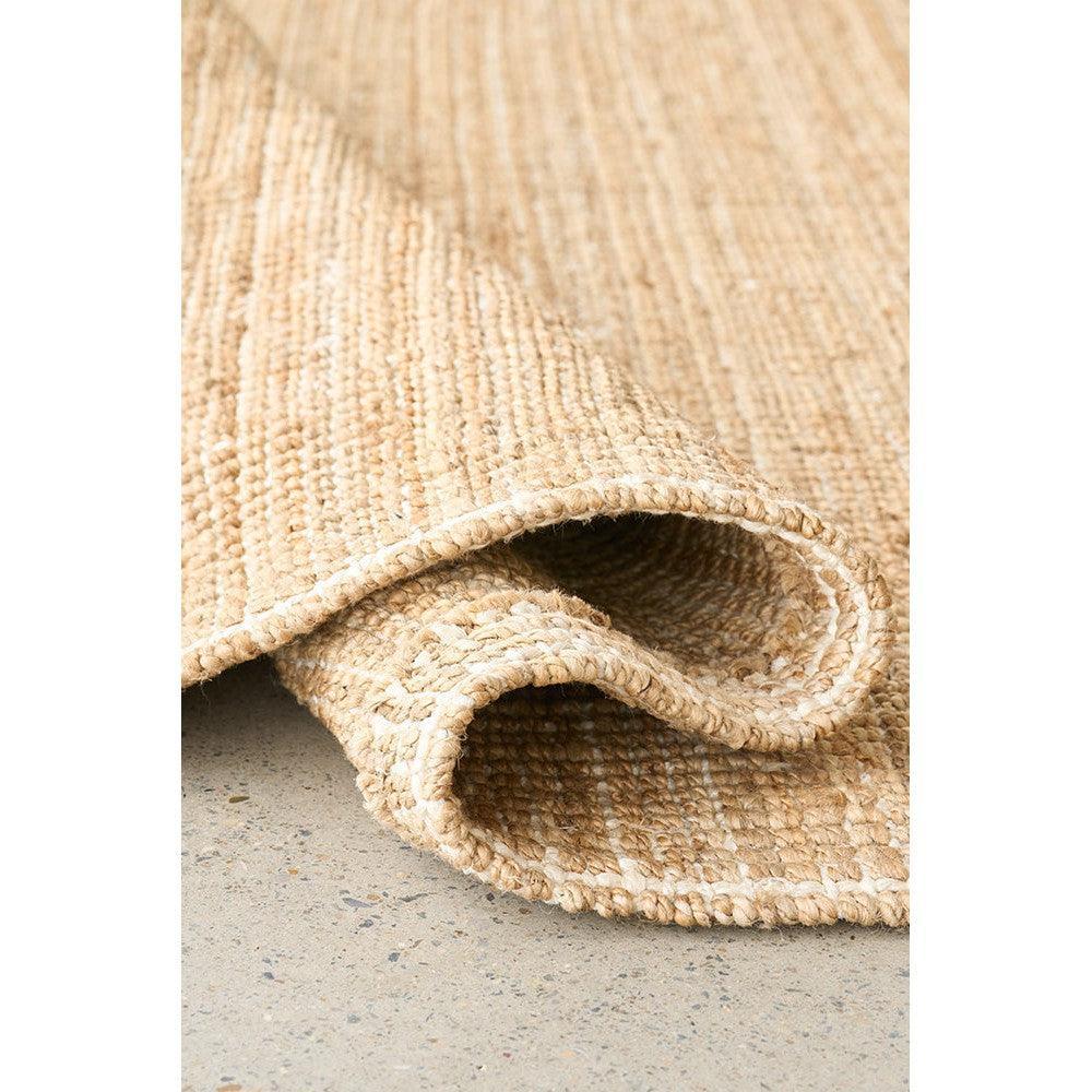 Madras Marlo Natural Runner Rug featuring woven striped pattern in beige, tan and cream on light grey concrete, handwoven jute