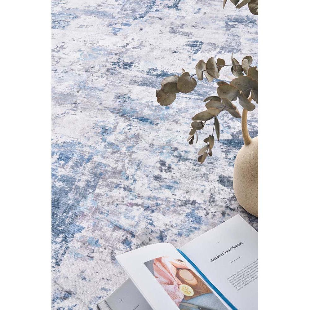 Revive Cato Blue Rug featuring abstract distressed pattern in blue, white and ivory on pale background, hand-tufted wool