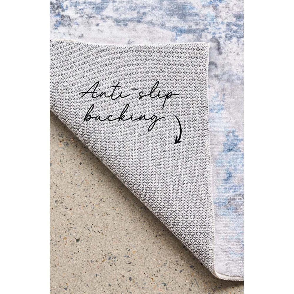 Revive Cato Blue Rug featuring abstract wash pattern in navy blue, powder blue, grey on light ivory background, anti-slip backing, machine-woven rug Culture